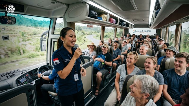 Tour guide Jana Dharma Indonesia sedang memandu rombongan peserta overland tour di dalam bus pariwisata.